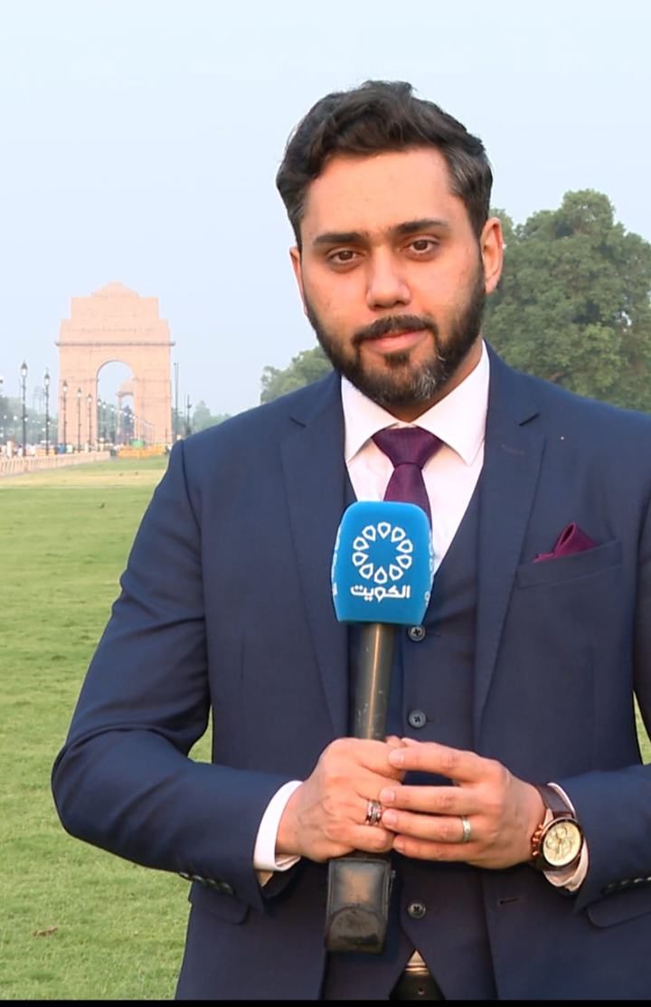 Dr. Sari Hamoud holding a blue television microphone on the lawns near India Gate, New Delhi